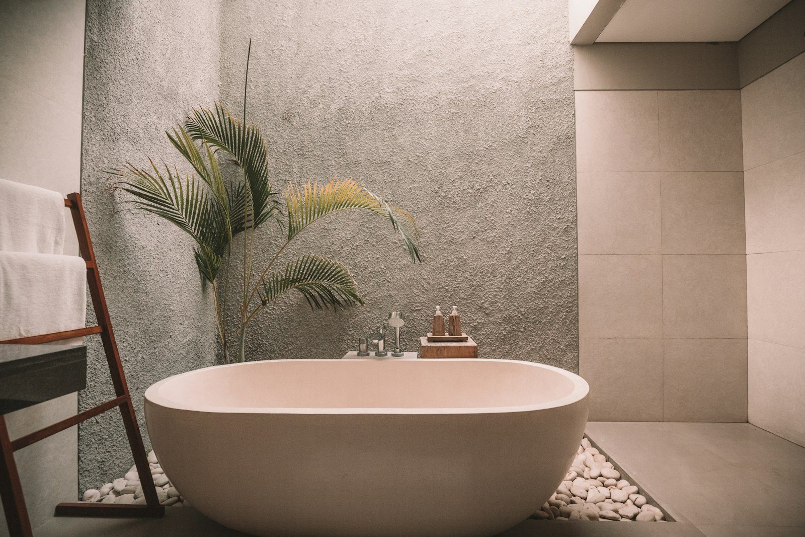 Spa-like bathroom with freestanding tub, soft stone, and warm wood accents